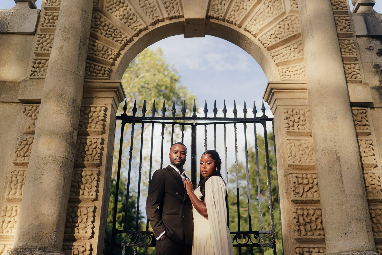 Davina and Peter beside ornate estate gates