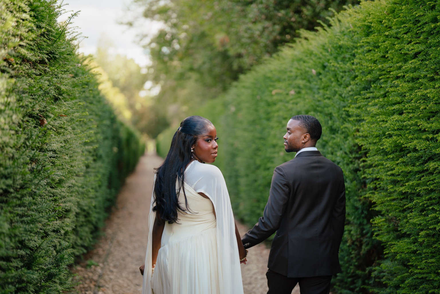 Davina and Peter walking hand in hand in the garden