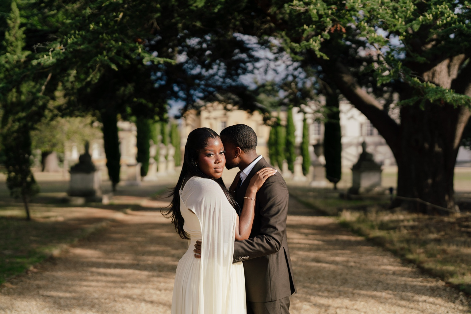 Davina and Peter embracing beneath trees